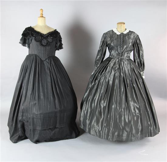La Traviata: A rail with a collection of 19th century style dresses in black velvet, grey silk, a white and mushroom cotton dress,
